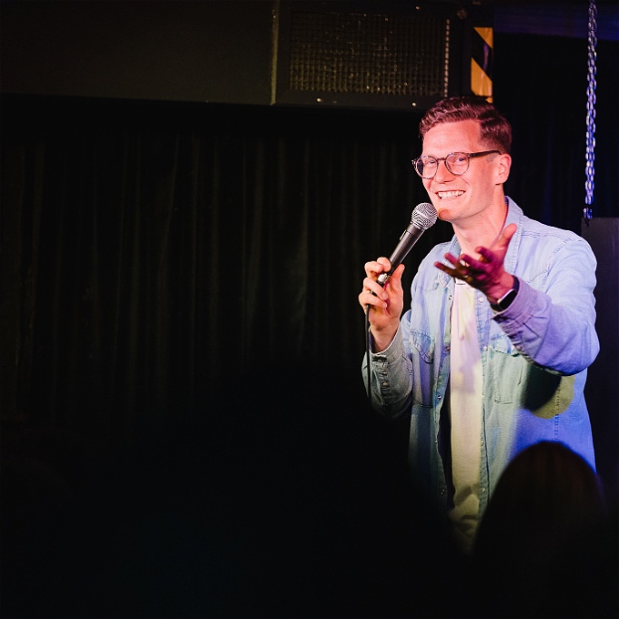 Robin Morgan, a comedian, holds a microphone during a performance